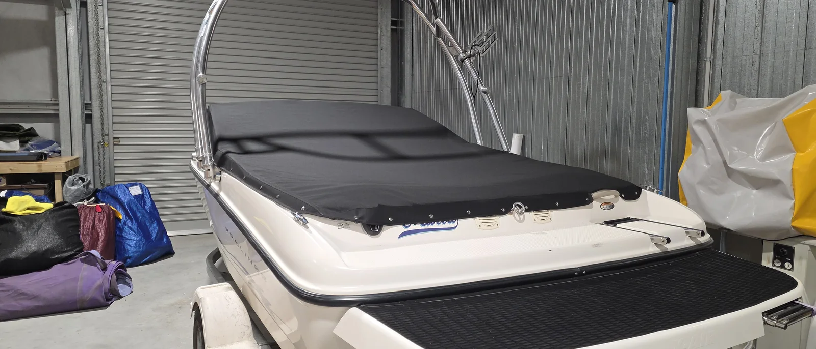 Custom-fitted black bow cover on a runabout boat with a wakeboard tower