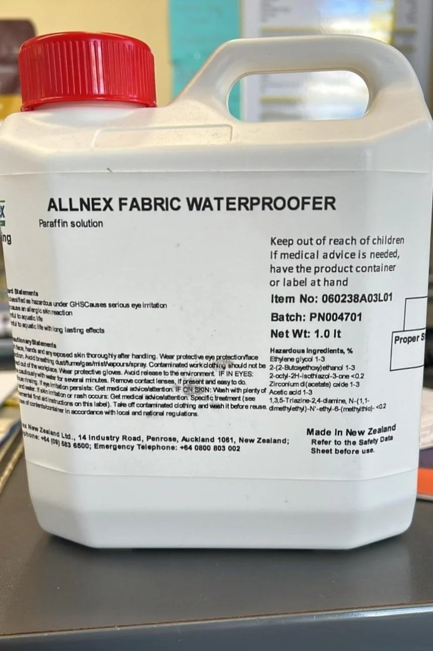 Bottle of canvas waterproofer sitting beside a canvas cover