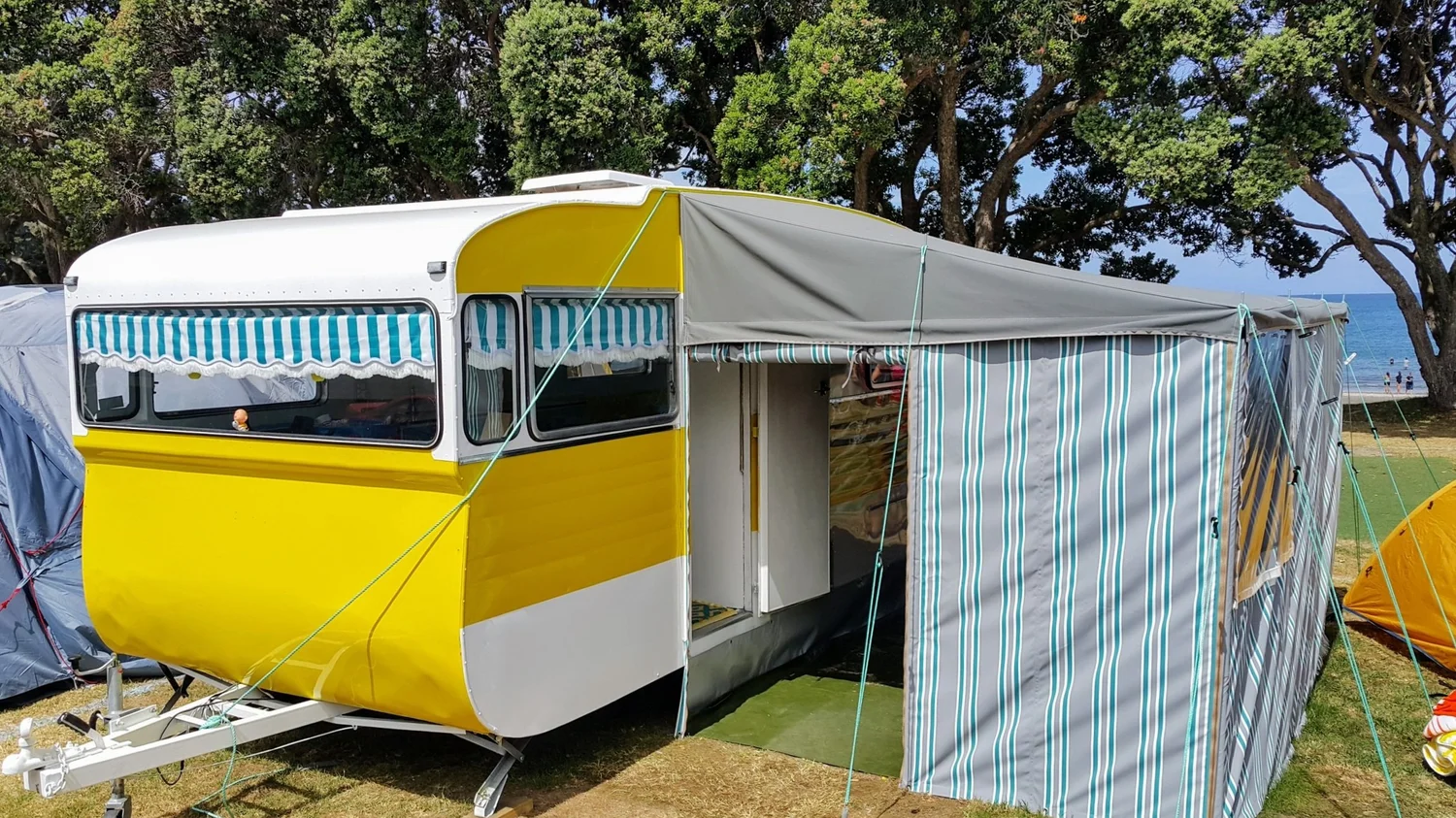 Caravan fitted with a full annexe-style awning with rafters and side walls