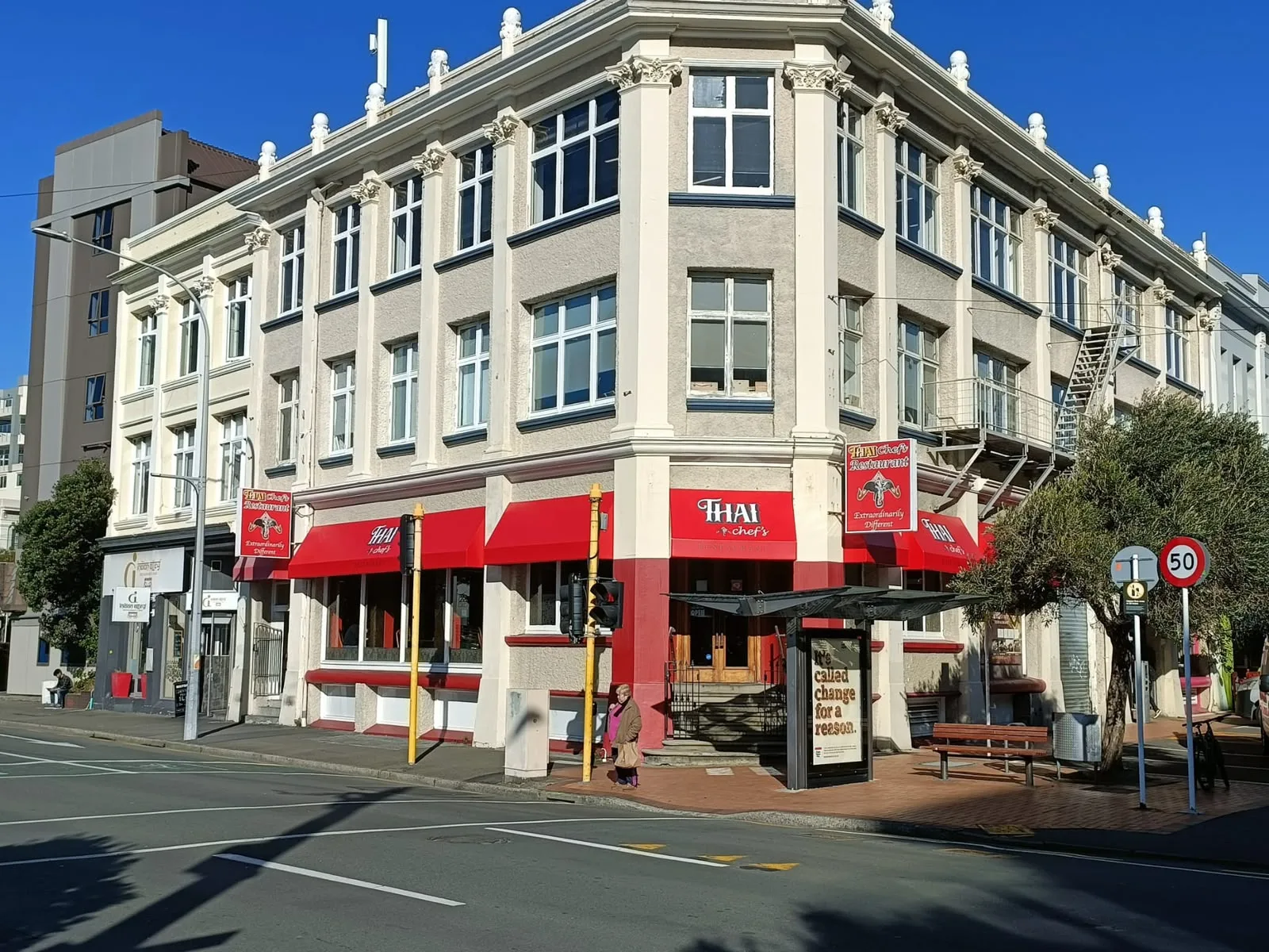 Red fixed awnings wrapping the corner of a commercial building