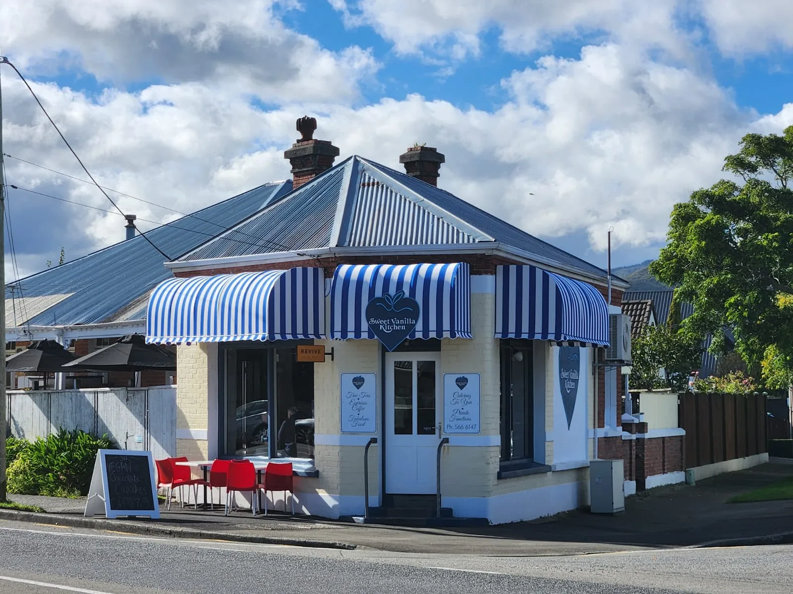 Blue and white striped fixed awnings across a heritage shopfront