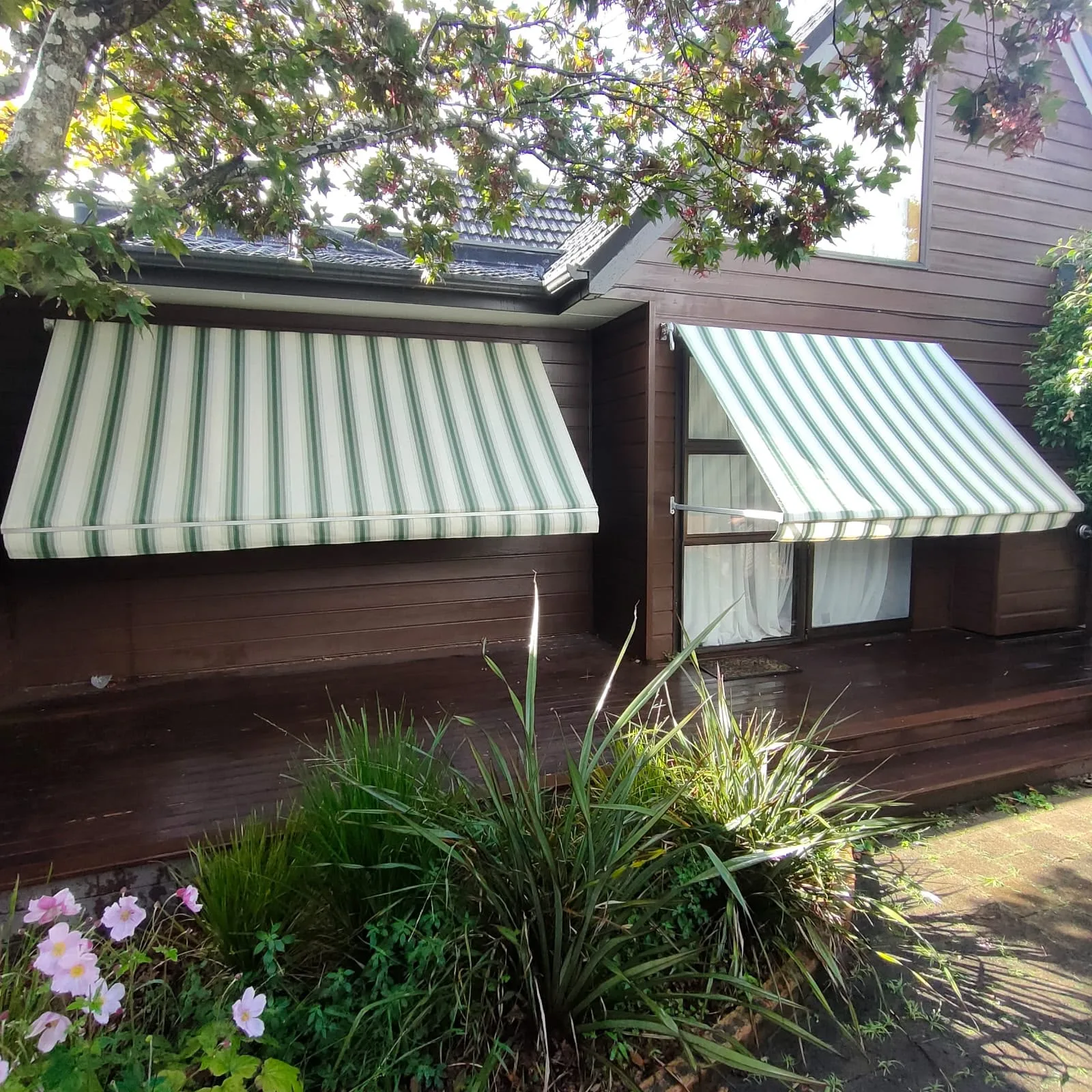 Green and white striped fixed awnings over two windows
