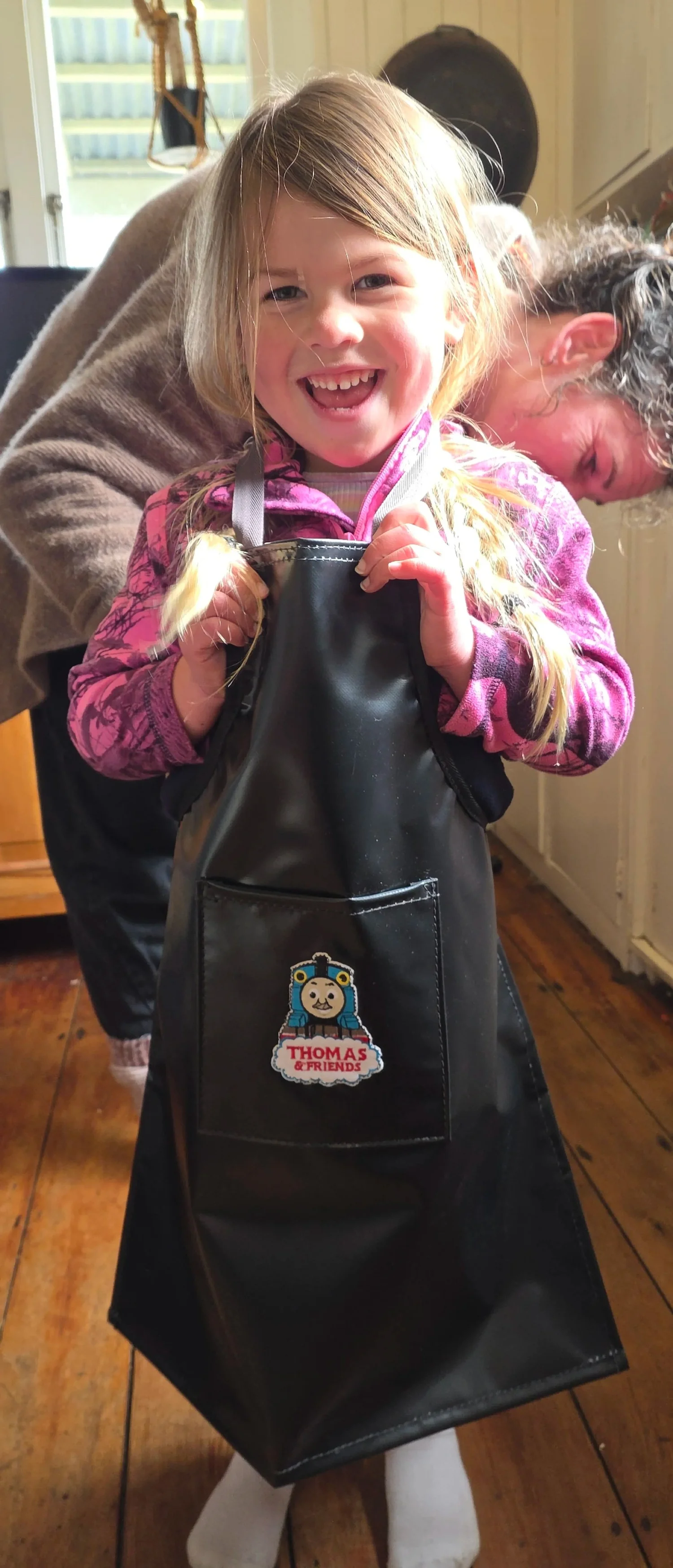Child wearing a printed PVC play apron