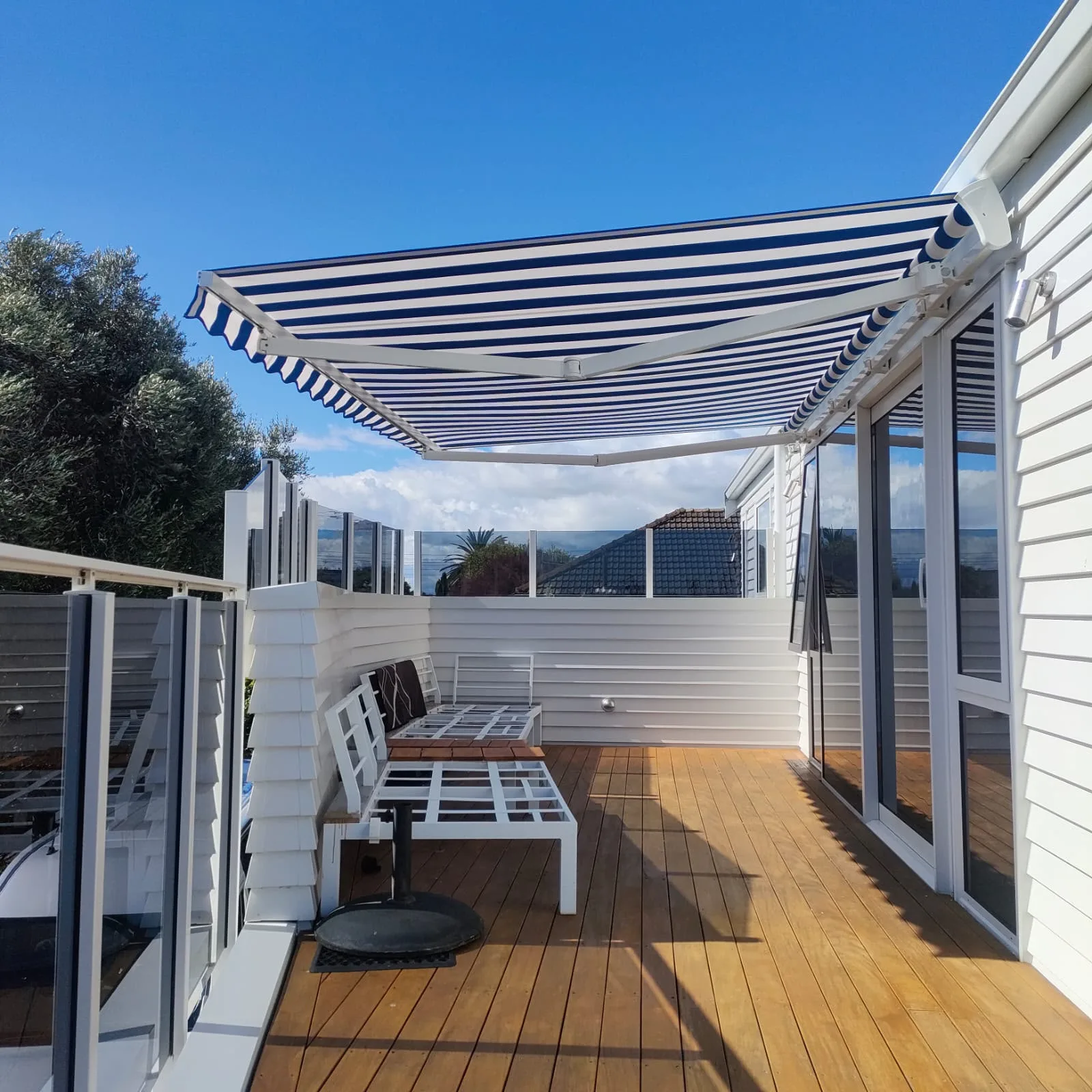 Striped lateral arm awning over an outdoor seating area
