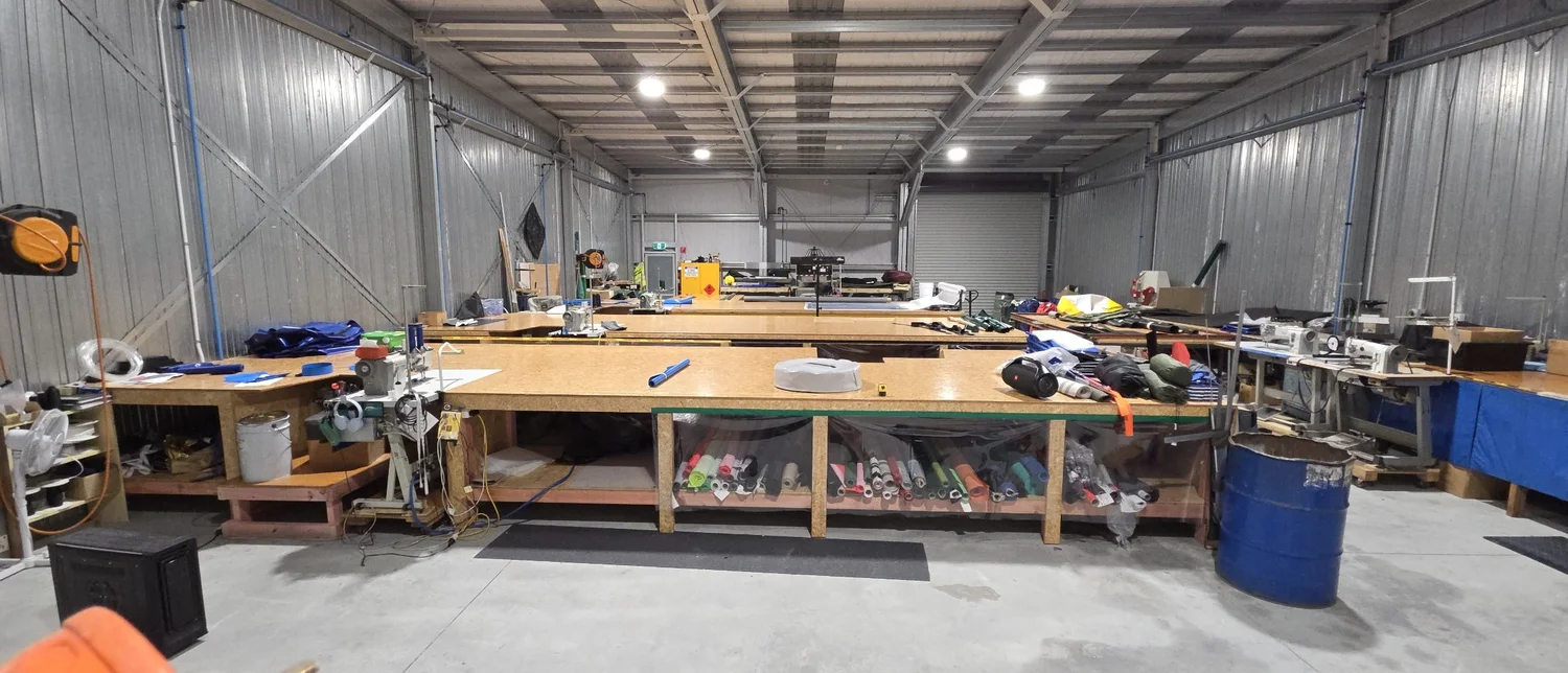 Interior of the Canvasland manufacturing workshop with workbenches and cutting equipment
