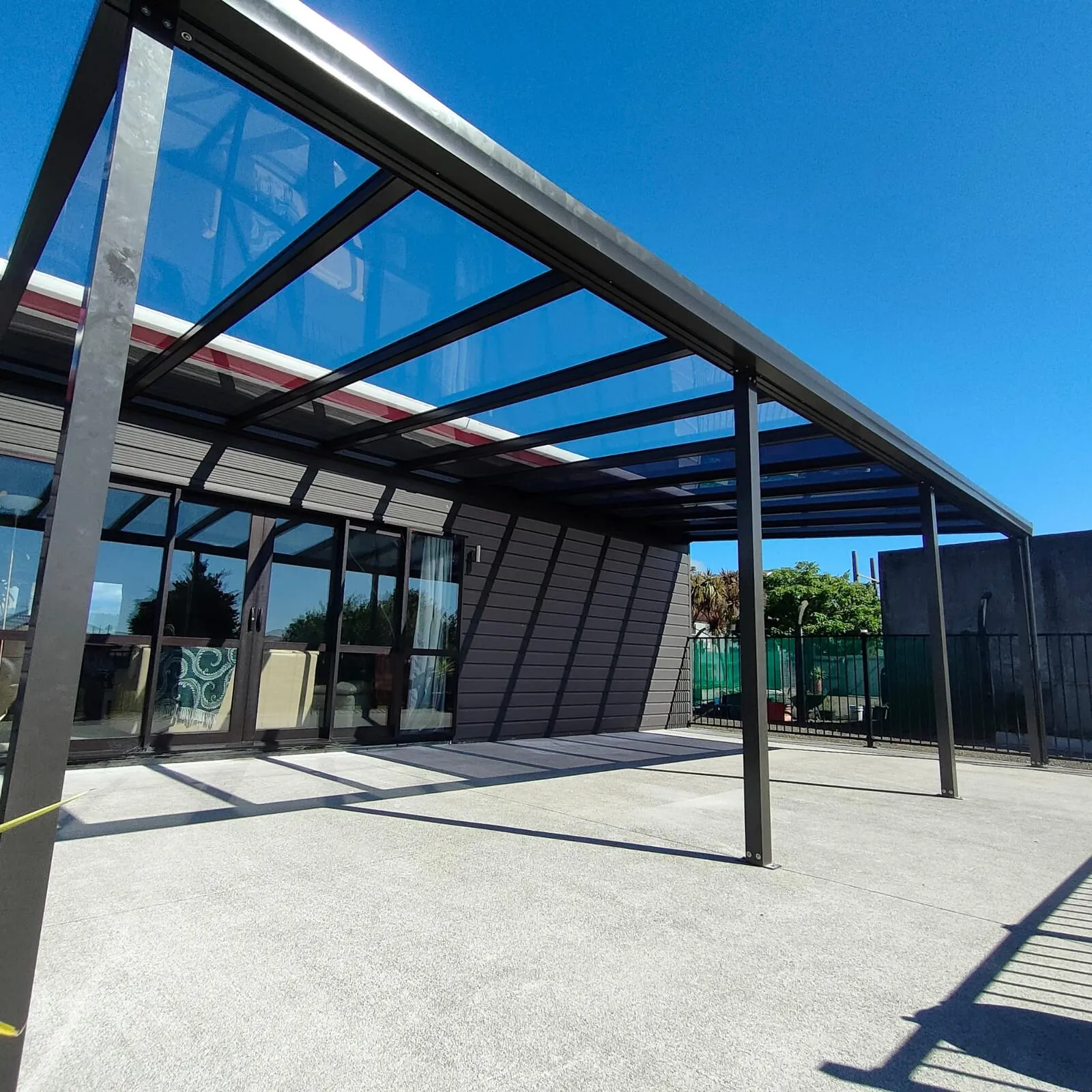 Acrylic sheet roof canopy on an aluminium frame, attached to a modern home