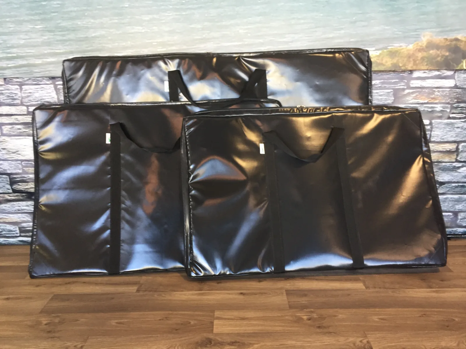 Three black PVC bags in different sizes, each with webbing handles