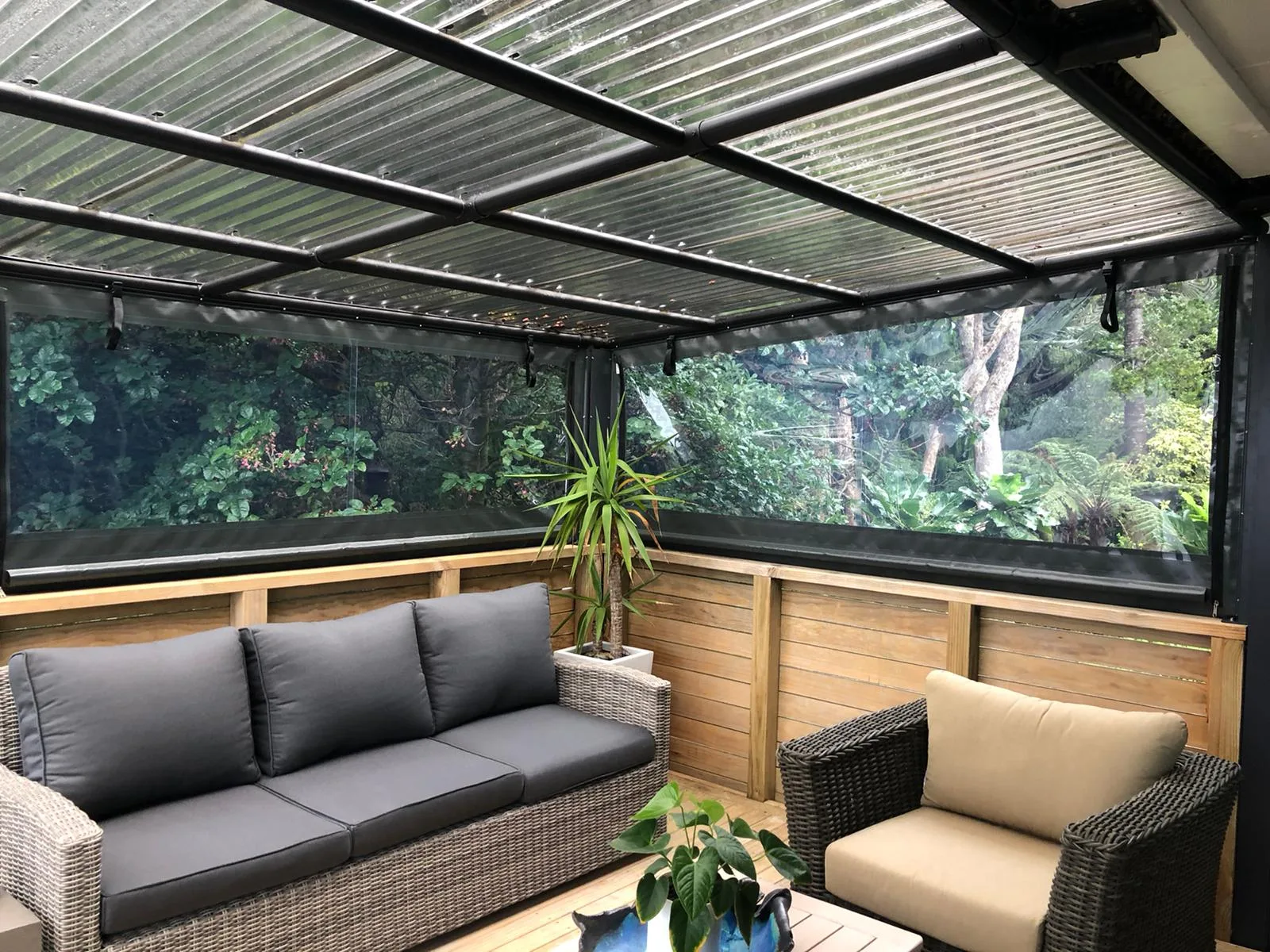 A covered outdoor lounge closed in with clear PVC blinds