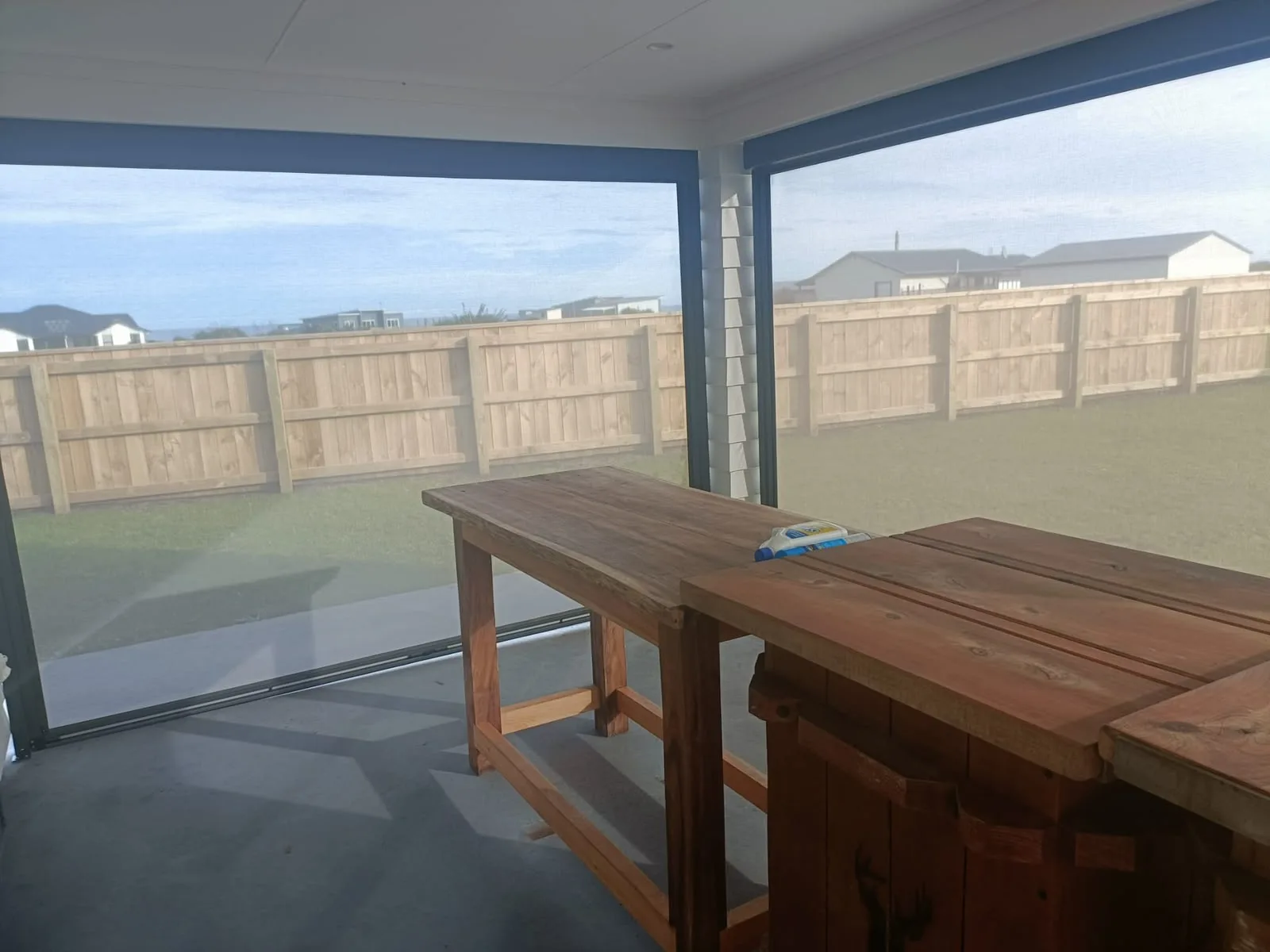 Clear PVC screens enclosing an outdoor room, with the garden visible through them