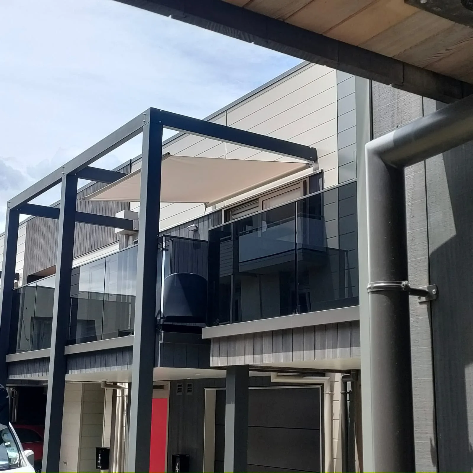 Shade sail tensioned against a modern multi-level building