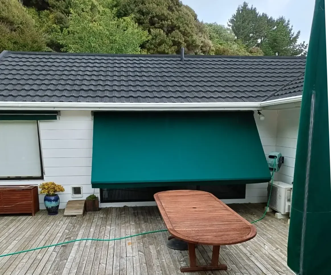 Green spring arm awning extended over a deck