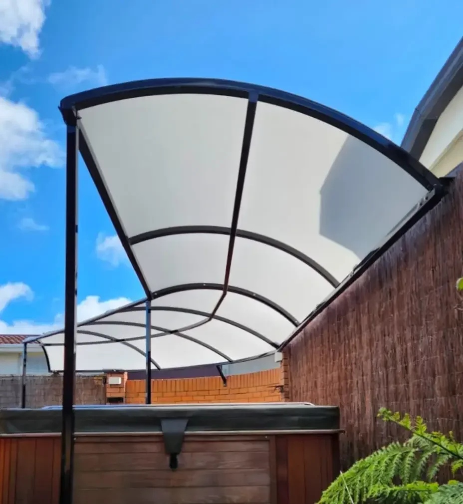 Residential tension canopy over a spa pool, dark arch frame with a curved white membrane