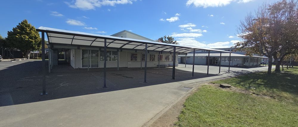 Tension canopy running along a school building
