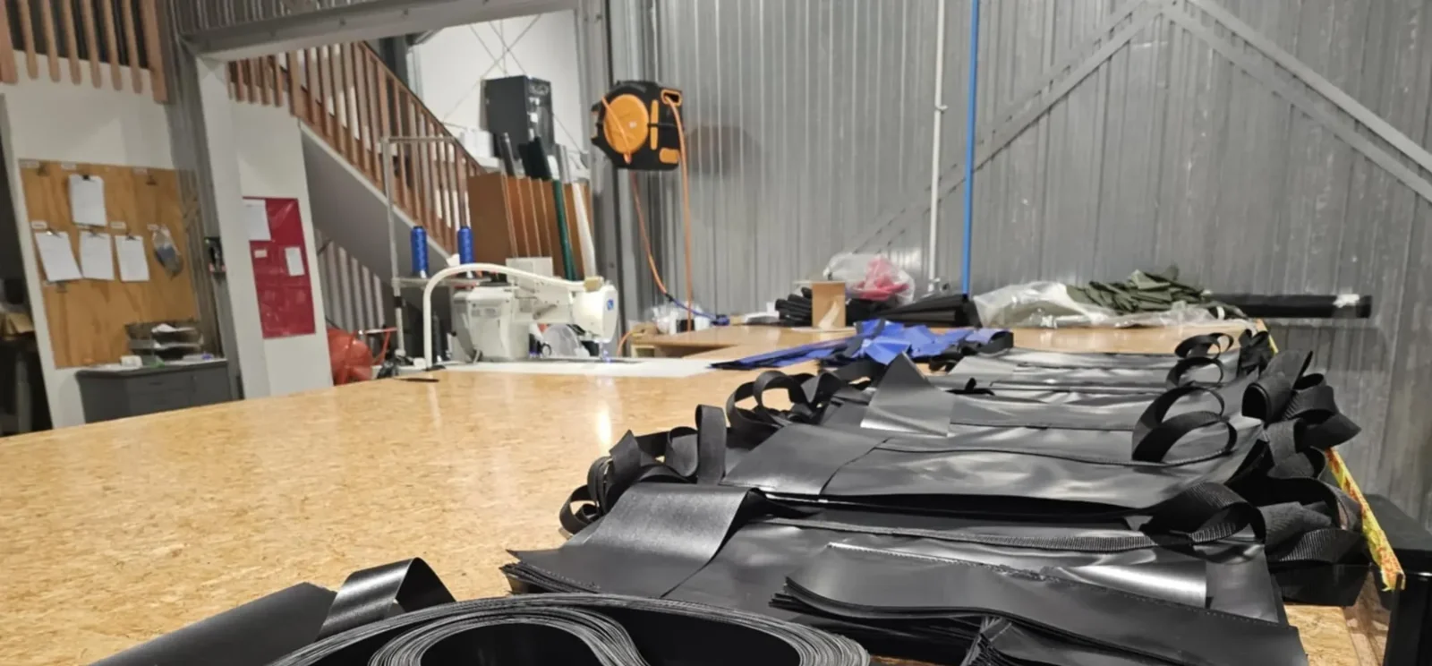 Welded PVC panels and webbing straps laid out on the workbench mid-build