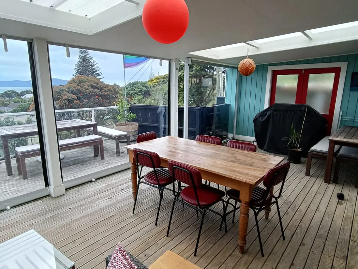 Inside a covered deck closed in with clear PVC blinds, looking out to the view