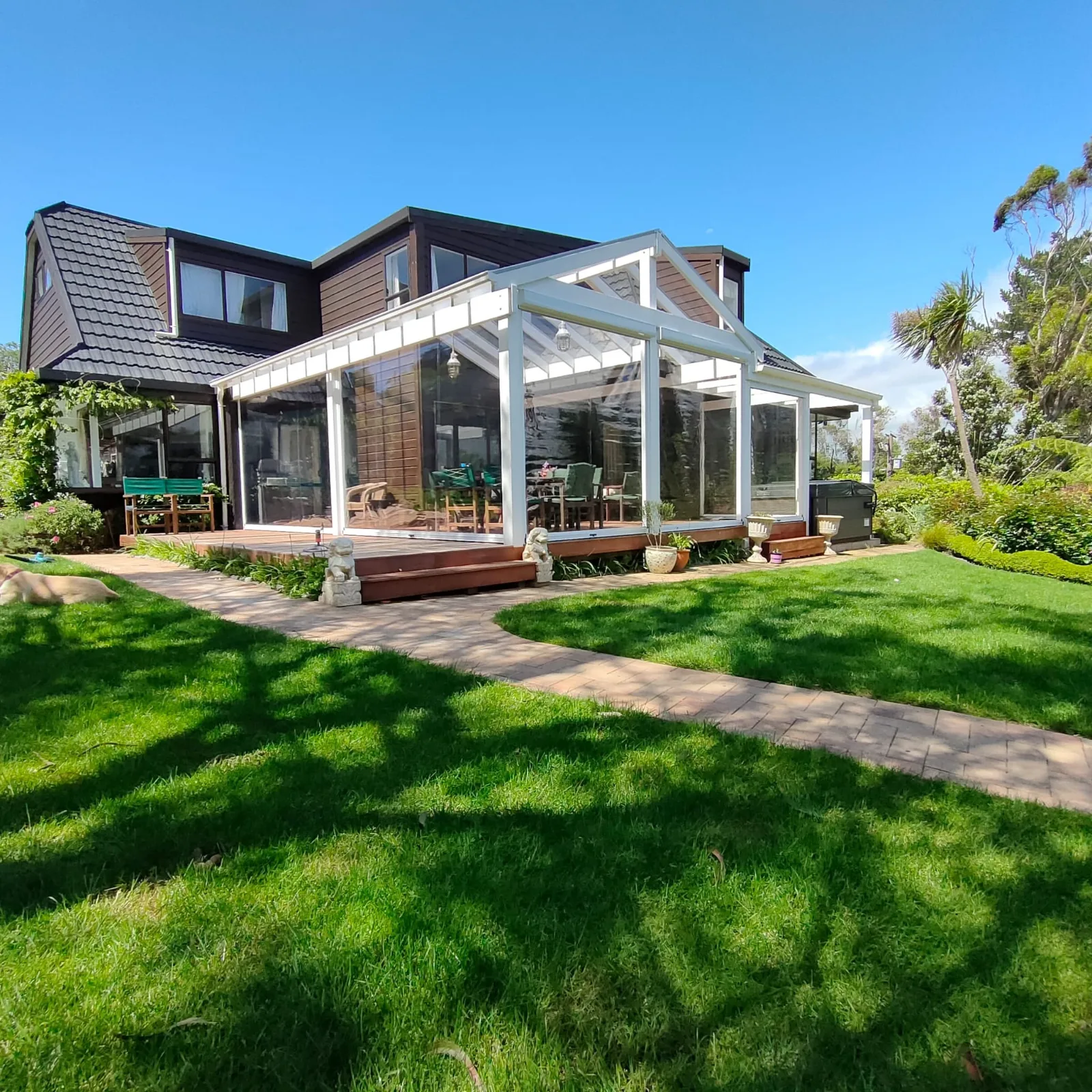 Ziptrak blinds enclosing an outdoor room, seen across the lawn