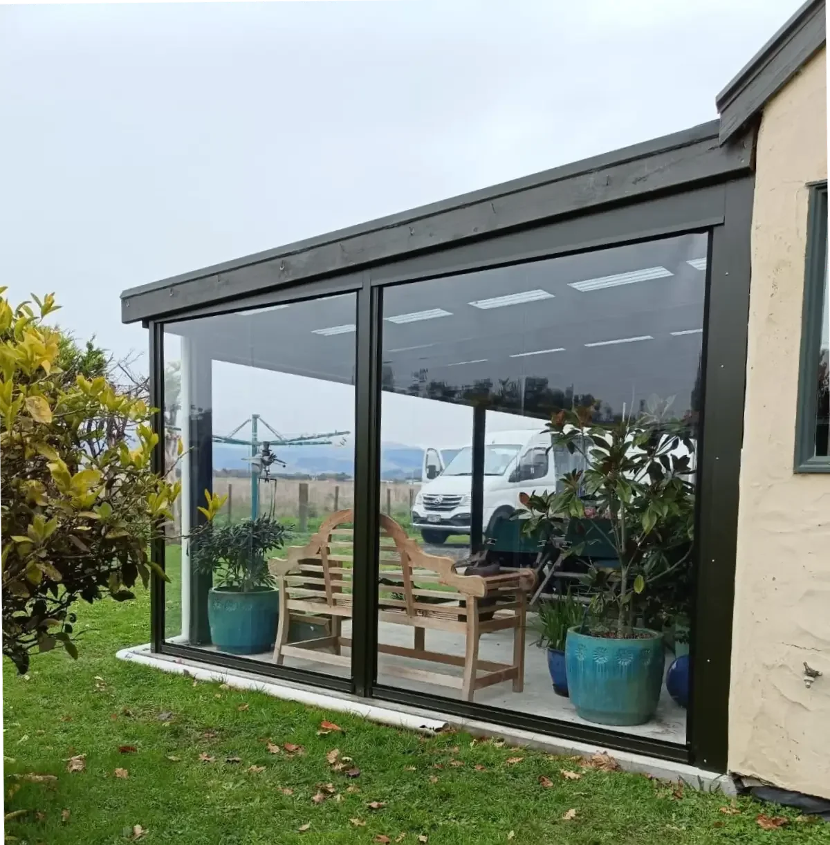 Ziptrak blinds part-raised on a modern outdoor room, opening it to the view